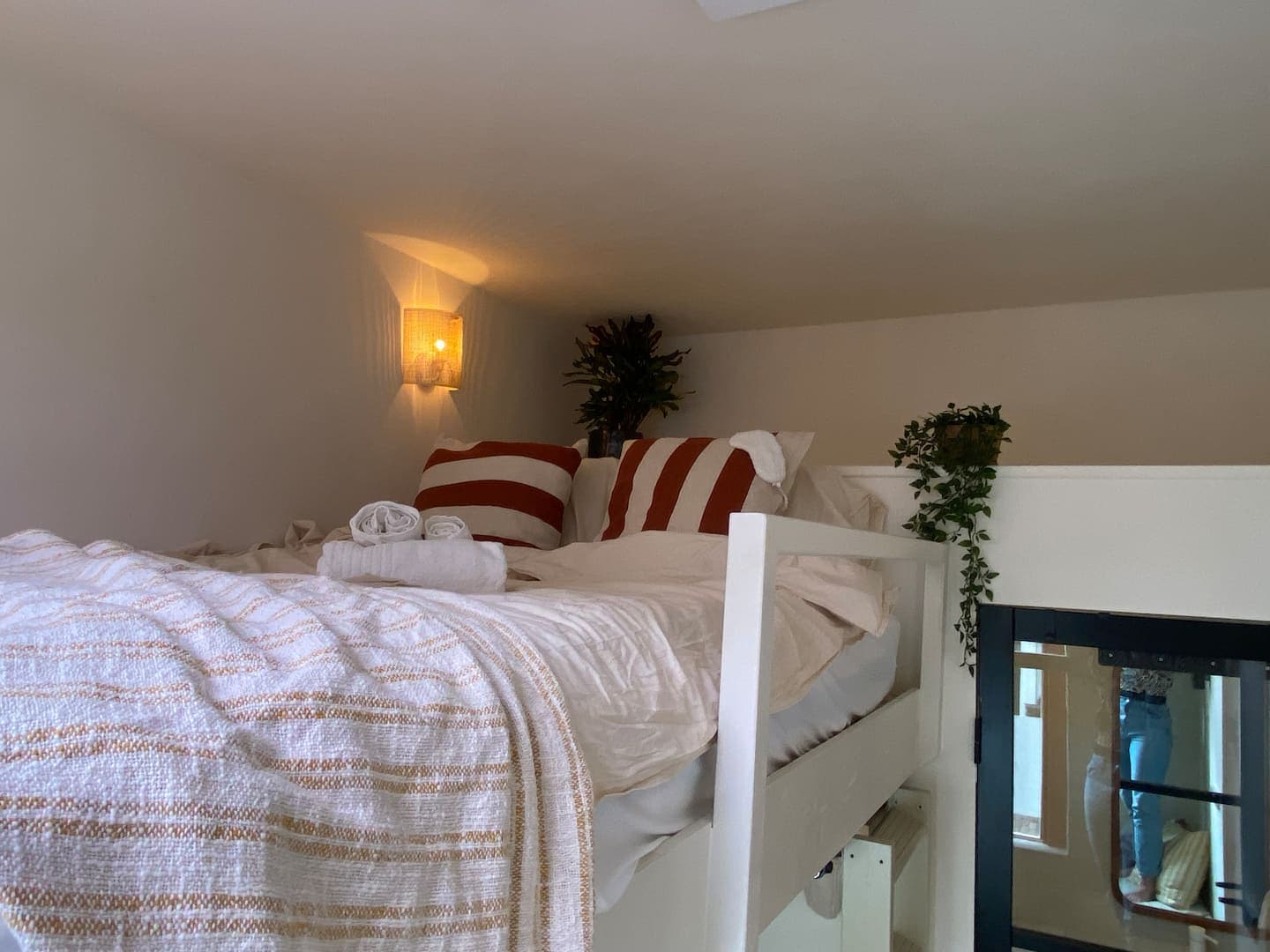Loft bed under the eaves with striped cushions