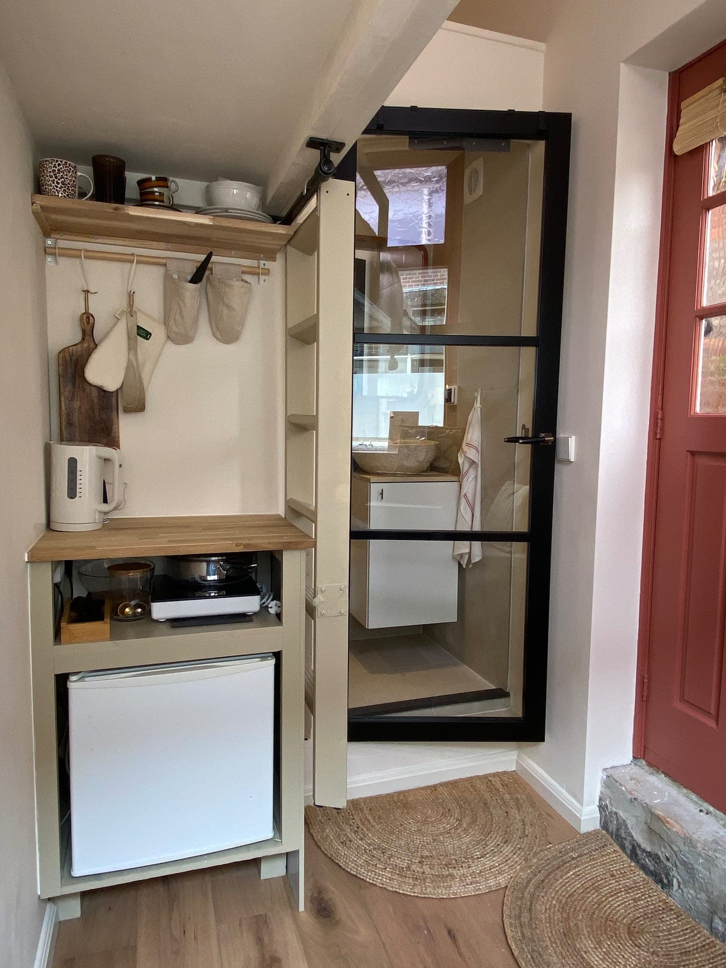 Compact kitchenette beside the glass-door bathroom