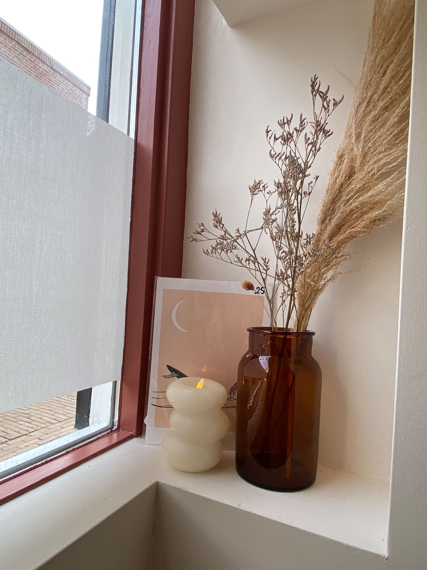 Window nook styled with dried flowers and a candle