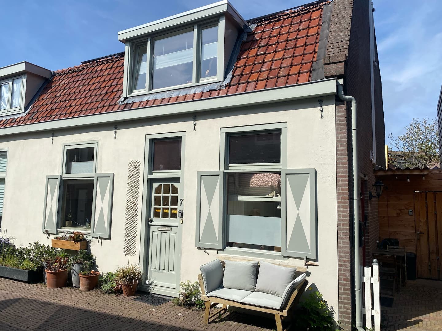 The cottage's whitewashed façade with a bench out front